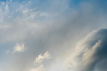 fluffy gentle clouds slowly and hopelessly float across the endless sea of blue sky. Clear blue sky after the raging elements and storms.