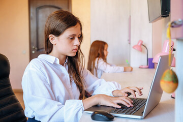 Obraz na płótnie Canvas Schoolgirl studying homework during her online lesson at home. Online education concept