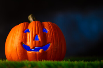 Halloween. Against the background of the dark night sky, a large orange pumpkin with a mystical smile, illuminated inside by a lantern.Banner, advertisement, postcard.