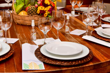 table set for dinner with white plates, glass glasses and alcohol to sanitize hands

