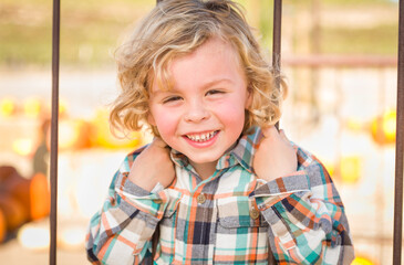 Little Boy Having Fun in a Rustic Ranch Setting at the Pumpkin Patch.