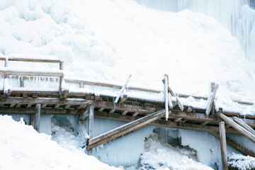 Obraz premium Small bridge under deep snow in woods 