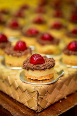 cream pie with chocolate and cherry on wooden table and blur in the background, candy showcase, condensed milk candy ,sweets table, candy store