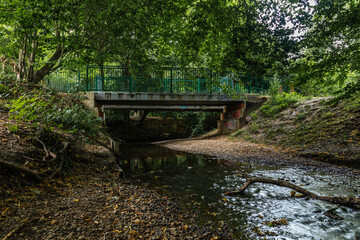 Fototapeta na wymiar A pedestrian bridge over the Dollis Brook along Dollis valley green walk.