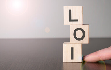 Businesswoman made word loi with wood building blocks.