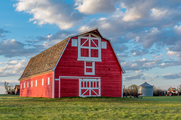 Vintage red barn in a farmyard on the prairies in Saskatchewan  - obrazy, fototapety, plakaty
