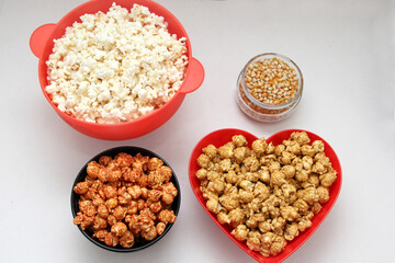 Fototapeta na wymiar Flavored popcorn: natural, with chili and with caramel, Variety of snacks with drinks ready to see a movie 