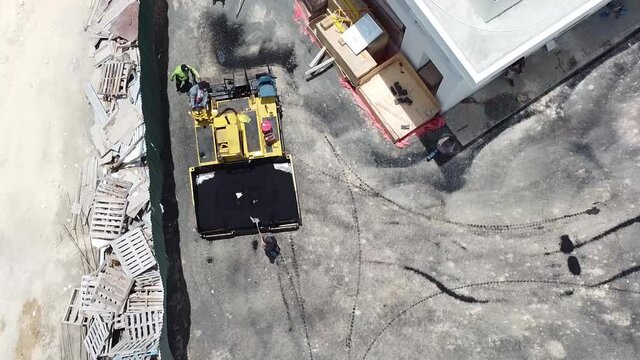Vista a&eacute;rea de maquinaria pesada para asfaltar calles, trabajador operando maquina de trabajo de proyecto de construccion