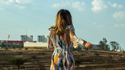 Mujer bailando a las afueras de ciudad