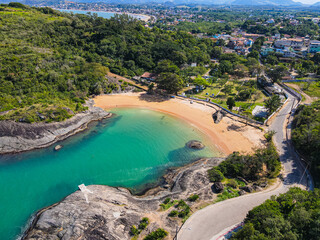 Obraz premium Visão aérea da praia de Setiba, na reginão norte de guarapari, mostando um dia ensolarado com barraquinhas e uma praia tropical deserta. Turismo no Espírito Santo.