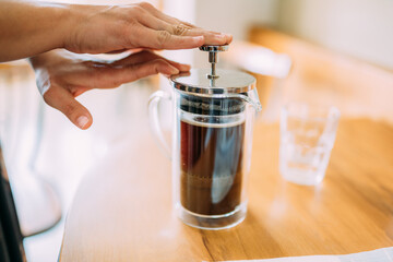 French press coffee. Friends waiting for coffee at the table in a Brazilian cafe shop.