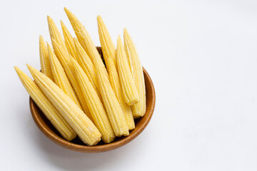 Baby corn in wooden bowl on white background.