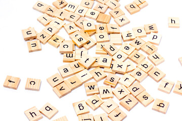 English alphabet made of square wooden tiles with the English alphabet scattered on white background. The concept of thinking development,grammar.