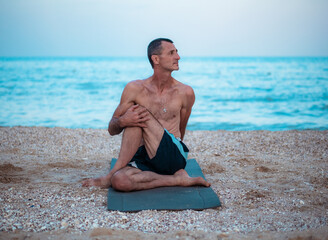 Fototapeta na wymiar man doing yoga by the sea