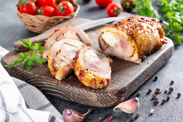Sliced baked until golden, crispy crust chicken roll, stuffed with cheese, herbs and mushrooms, garnish of vegetables.