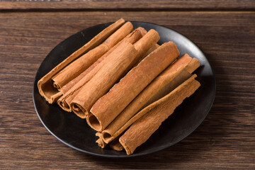 Aromatic dry cinnamon sticks on wooden background