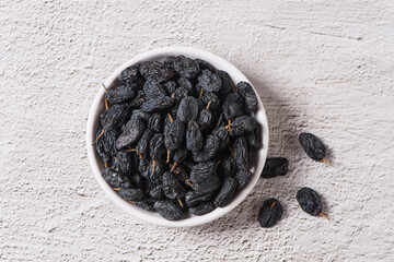 Dried fruits, pile of black raisins on table.