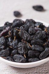 Dried fruits, pile of black raisins on table.