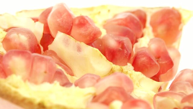 4K Organic healthy red fruit close-up. Open pomegranate fruit rotates on a white  background. Pomegranate seeds.