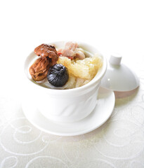 double boiled premium seafood with fish maw, black garlic, mushroom, chicken soup pot in white background asian halal seafood menu