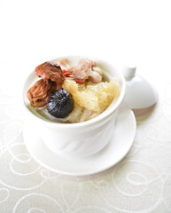 double boiled premium seafood with fish maw, black garlic, mushroom, chicken soup pot in white background asian halal seafood menu
