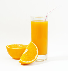 A cup of golden orange juice and two fresh orange slices on a white background