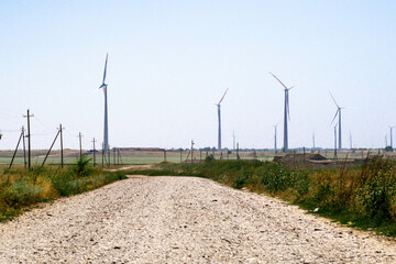 Fototapeta na wymiar a wind farm in the steppe in the foreground is a road