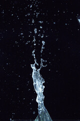 Naklejka na ściany i meble Close-up splash of water on black background, like a trophy, abstract art
