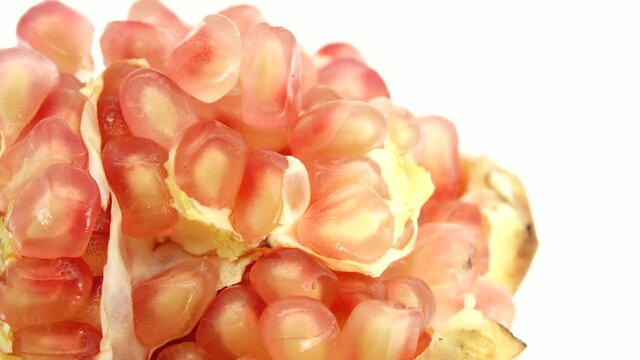 4K Organic healthy red fruit close-up. Open pomegranate fruit rotates on a white  background. Pomegranate seeds.