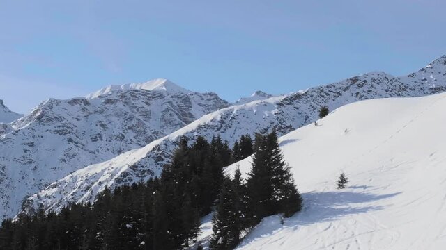 Aerial view of mountains in Winter at Arosa Lenzerheide ski resort, Switzerland - chairlift angle. Parallax effect, slow motion, no people, Winter, snow.