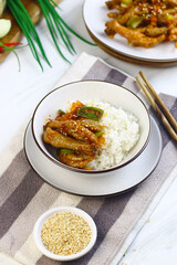 Korean Spicy Chicken feet or ceker ayam saus Gochujang served on white plate with sesame seed and slices onion spring. Bright mood food photography.