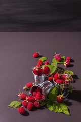 Obraz na płótnie Canvas Ripe raspberries on a black stone concrete background