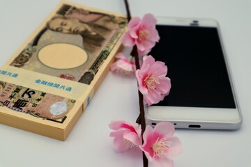 日本の紙幣とスマートフォン