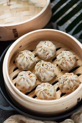 Close-up of a bamboo steamer with asian soup dumplings, selective focus, vertical shot