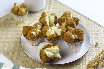 Bolu Kukus Cokelat or Flower bloom steam cake, Indonesian traditional cake, with chocolate flavour. White bright background. Morning tea concept.