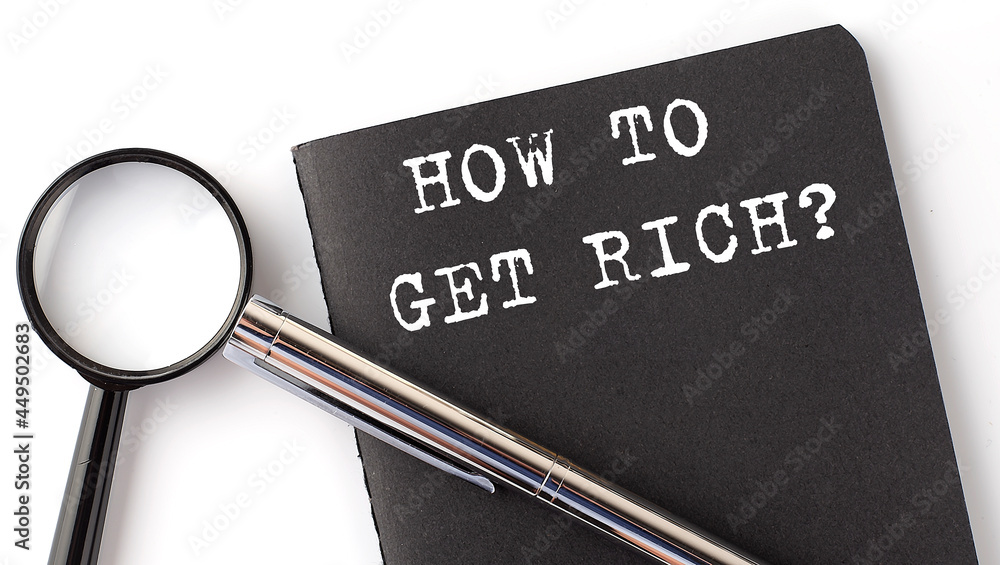 Poster how to get rich - business concept, magnifier with white text message on the black notebook