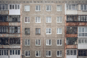Facade of a grey multi-storey soviet panel building