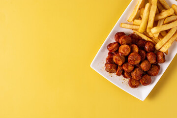 Traditional German currywurst on yellow background. Suasages with ketchup and curry	