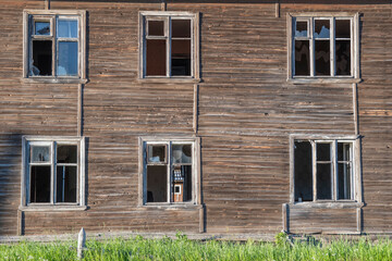 Old destroyed abandoned raw wooden house with the broken out windows