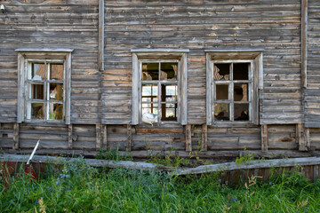 Fototapeta na wymiar Old destroyed abandoned raw wooden house with the broken out windows