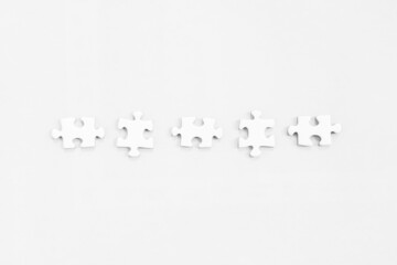 Five white jigsaw puzzles, on white background