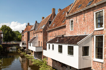 Fototapeta na wymiar Old houses with attached kitchens above the canal in the picturesque town of Appingedam in the province of Groningen; Netherlands.