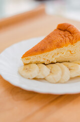 Close-up of cheesecake with banana on a white plate