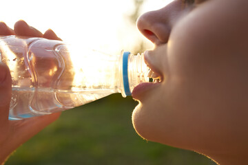 cheerful woman drinking water from a bottle summer close-up