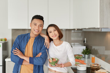 Happy smiling family couple cooking on loft kitchen.