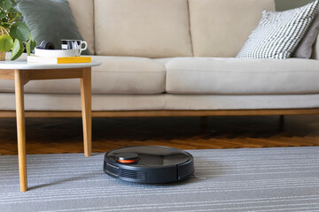 Robot vacuum cleaner on the carpet. Cleaning in living room at home