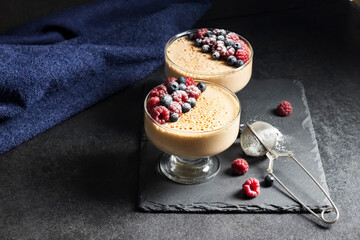 Ryazhenka mousse in glass bowls decorated with fresh berries