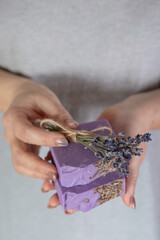 Woman holds a stack of handmade soap.