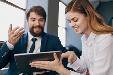 man and woman in business suits communicate with the tablet managers professionals