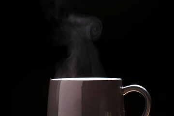 Close up Cup of coffee, coffee with smoke isolated on black background.	